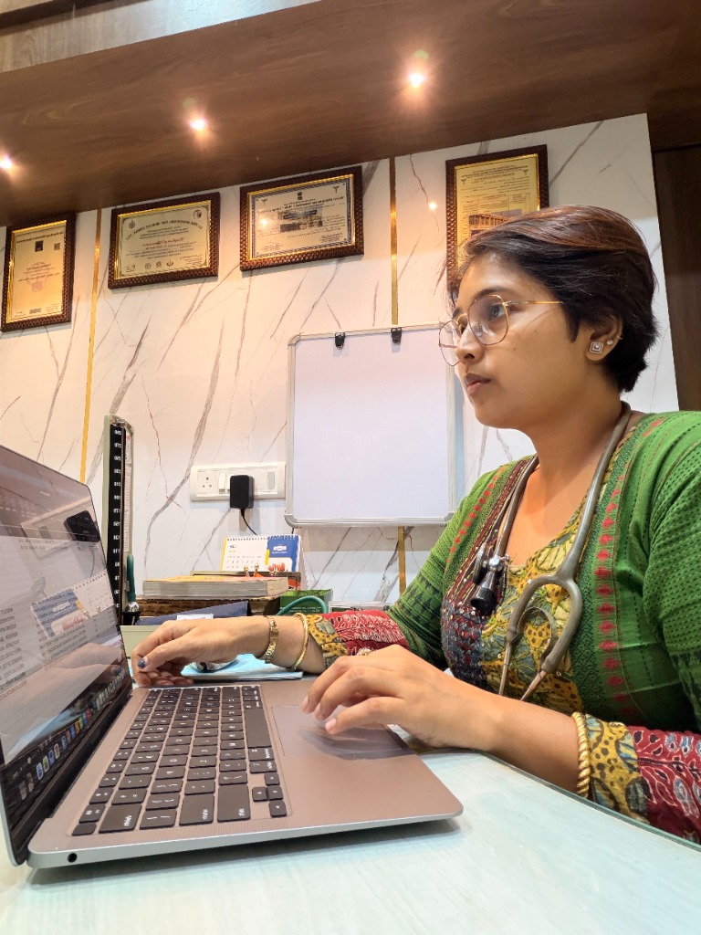 Dr. Poulamy consulting with a patient on laptop